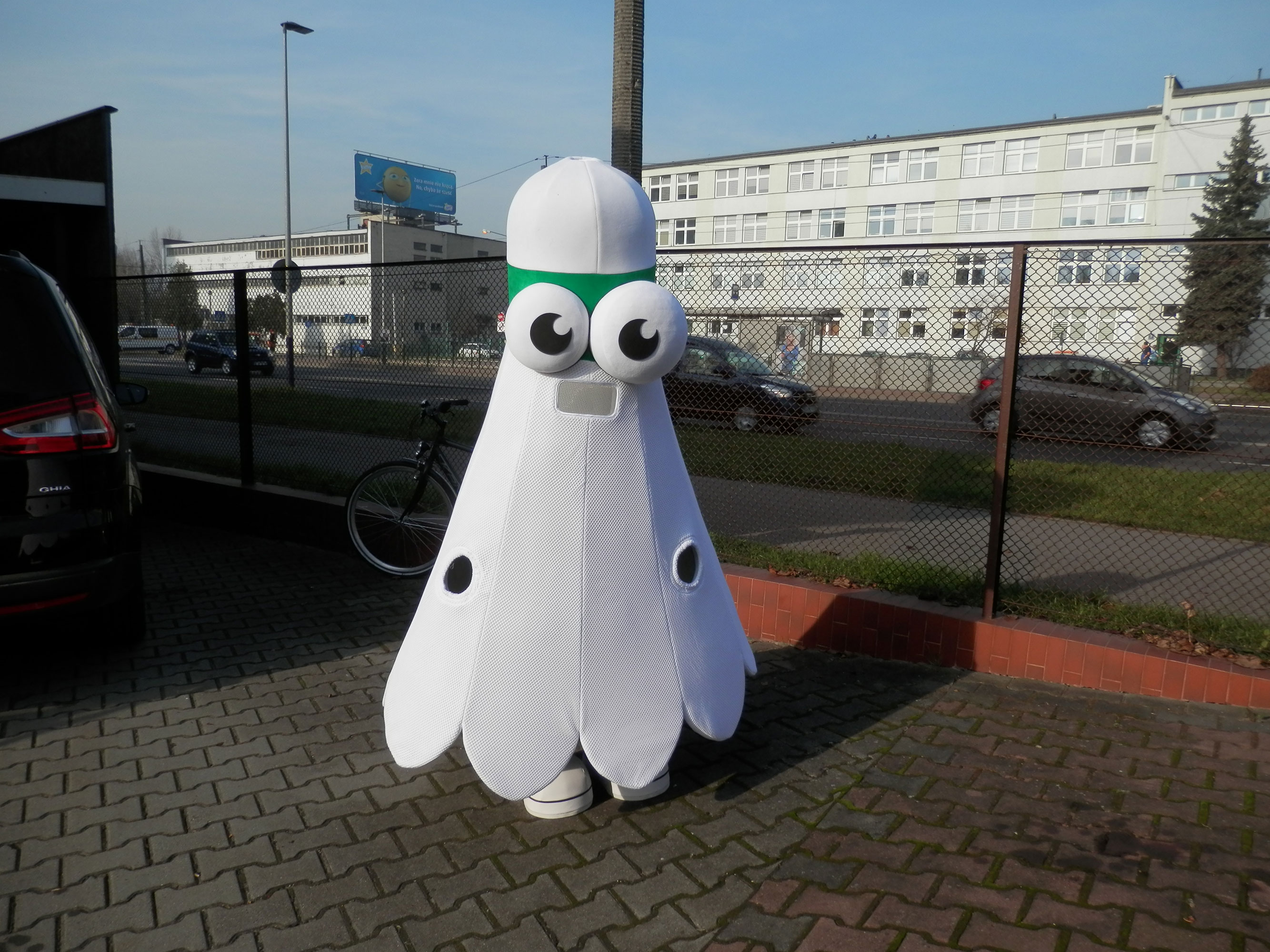 Na fotografii widnieje maskotka kostium Lotka stojący na krakowskiej ulicy